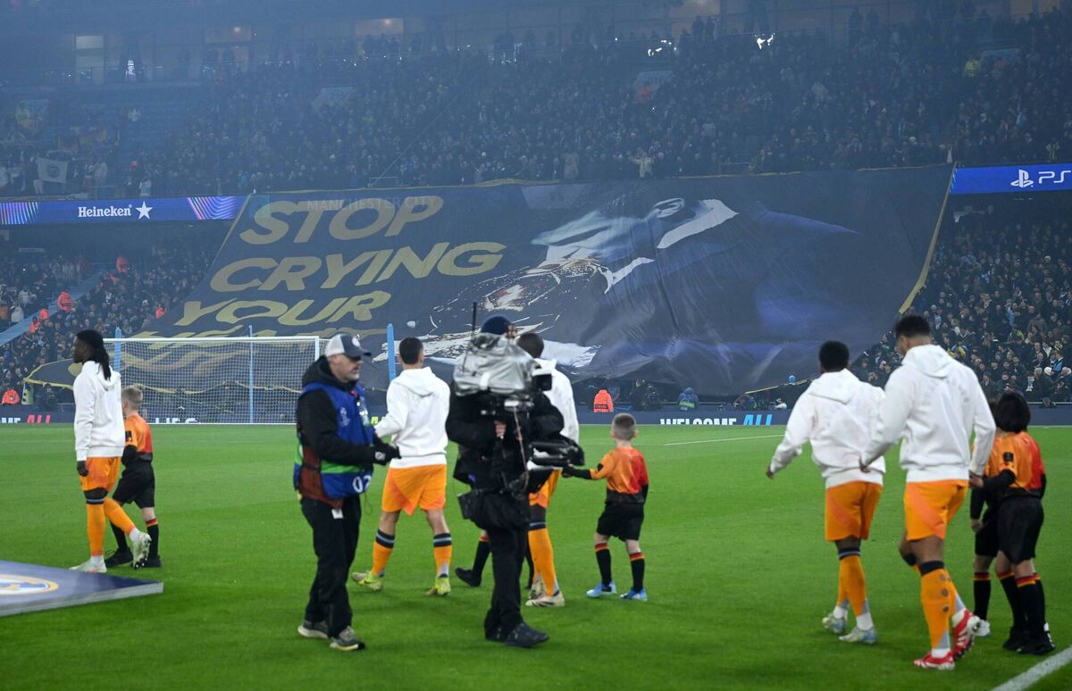 Fans of Manchester City display a tifo which reads 'Stop crying your heart out' which includes a picture of Rodri of Manchester City kissing the Ballon d'or trophy. 