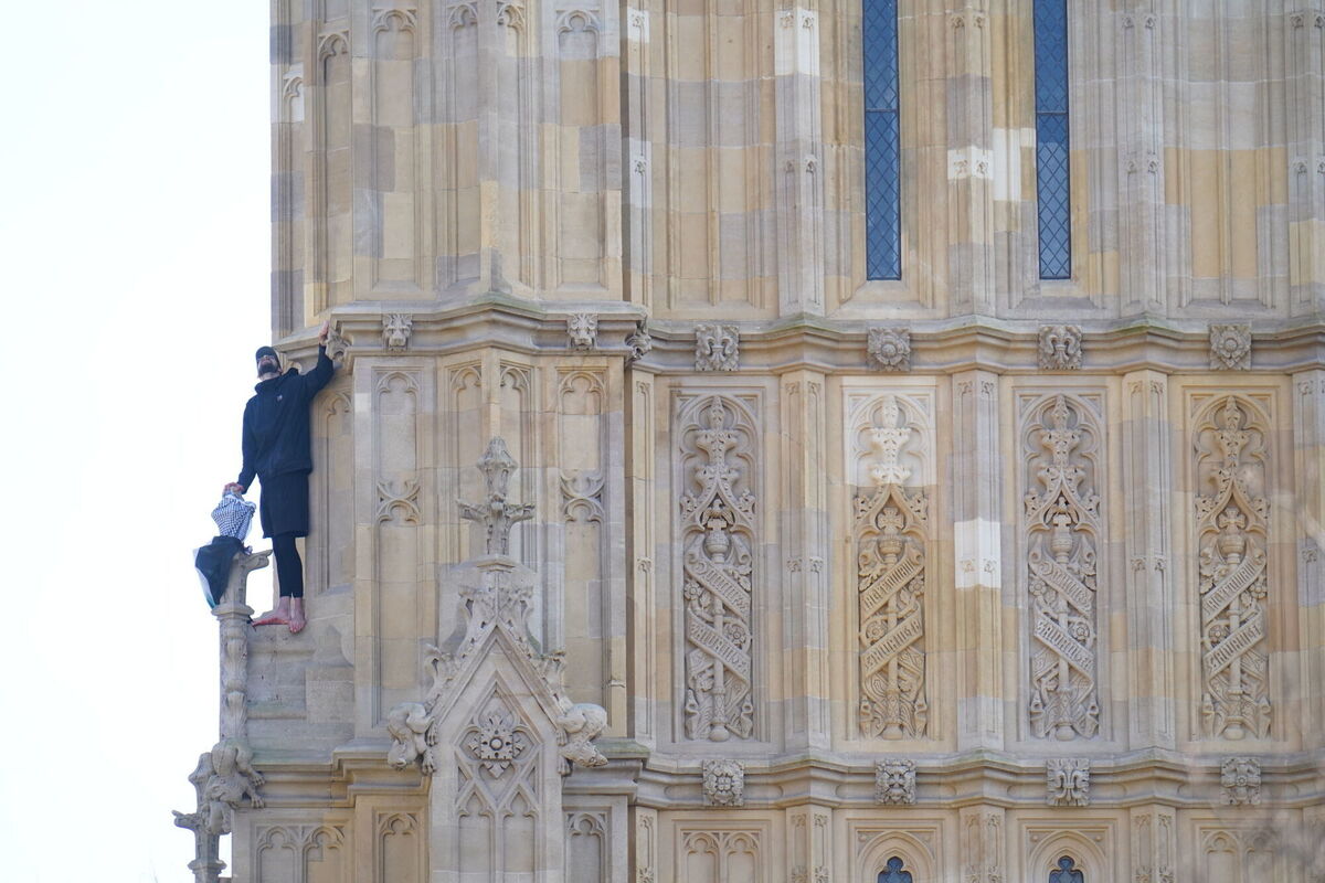 People watch a man with a Palestine flag after he climbed up Elizabeth Tower, which houses Big Ben at the Palace of Westminster in London. Picture date: Saturday March 8, 2025. PA Photo. See PA story POLICE Westminster. Photo credit should read: James Manning/PA Wire People watch a man with a Palestine flag after he climbed up Elizabeth Tower, which houses Big Ben at the Palace of Westminster in London. Picture date: Saturday March 8, 2025. PA Photo. See PA story POLICE Westminster. Photo credit should read: James Manning/PA Wire