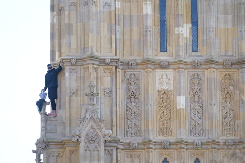 People watch a man with a Palestine flag after he climbed up Elizabeth Tower, which houses Big Ben at the Palace of Westminster in London. Picture date: Saturday March 8, 2025. PA Photo. See PA story POLICE Westminster. Photo credit should read: James Manning/PA Wire