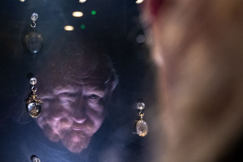 Paranormal investigator with GhostÉire, Anthony Kerrigan, looks at his reflection on the display of mourning jewellery made from human remains in Wake Museum in Waterford. 