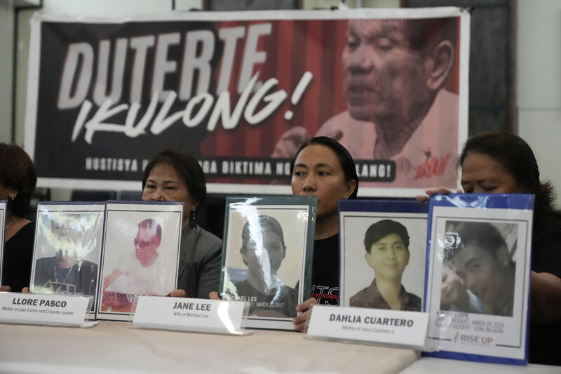 Relatives hold pictures of victims of alleged extra-judicial killings in front of a picture of former Philippine president Rodrigo Duterte with a sign that says "Jail Duterte" today. Many of these murders left no evidence. Photo: AP/Aaron Favila