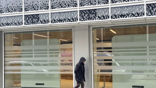 A man walks past the headquarters of Huawei in Brussels (Sylvain Plazy/AP)