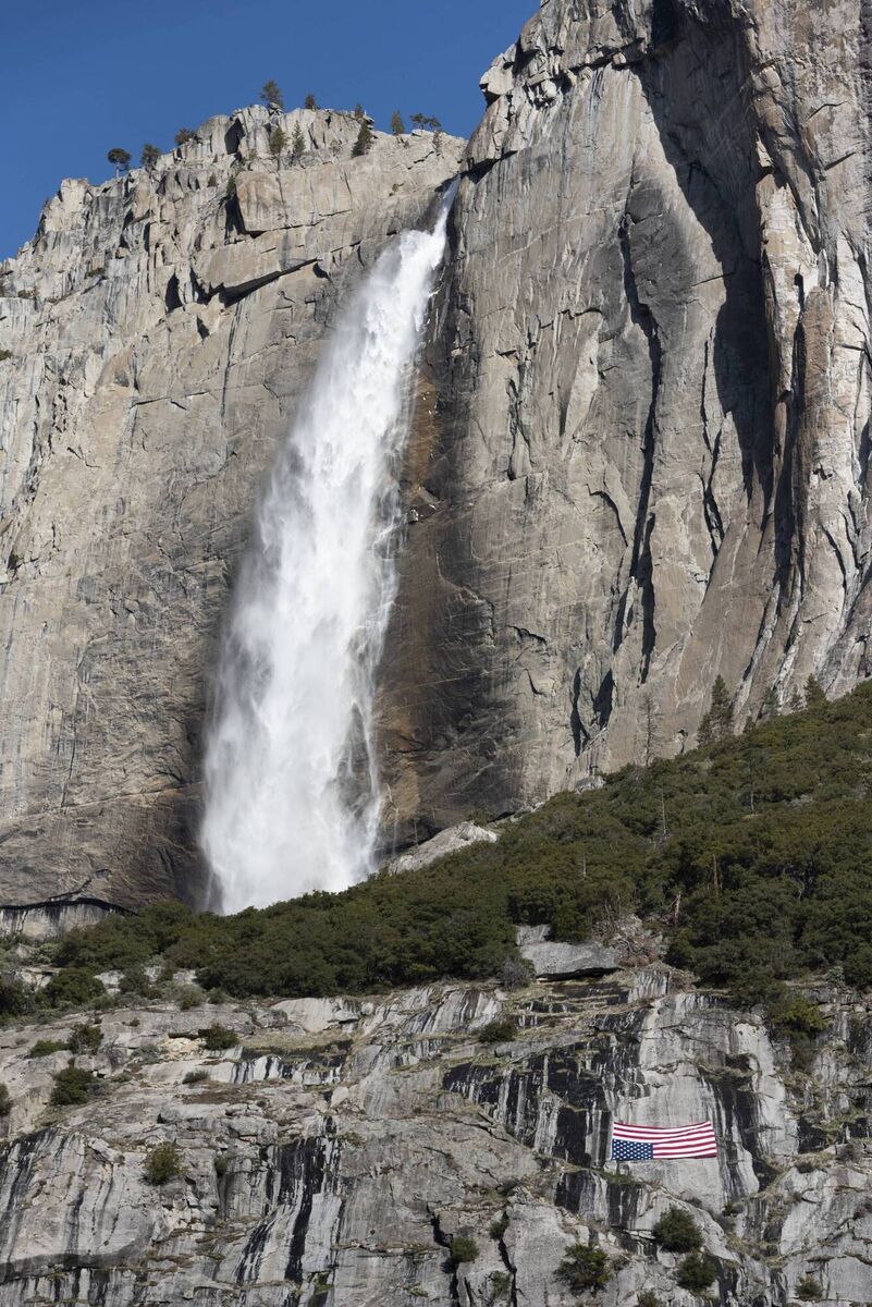 A US flag hanging upside down below the Upper Yosemite Falls during a protest against federal employee layoffs. The cuts were part of the work of the newly-created Department of Government Efficiency (DOGE), led by billionaire Elon Musk, as part of a declared effort to reduce public spending by dismantling the federal bureaucracy. Picture: Laure Andrillon / AFP
