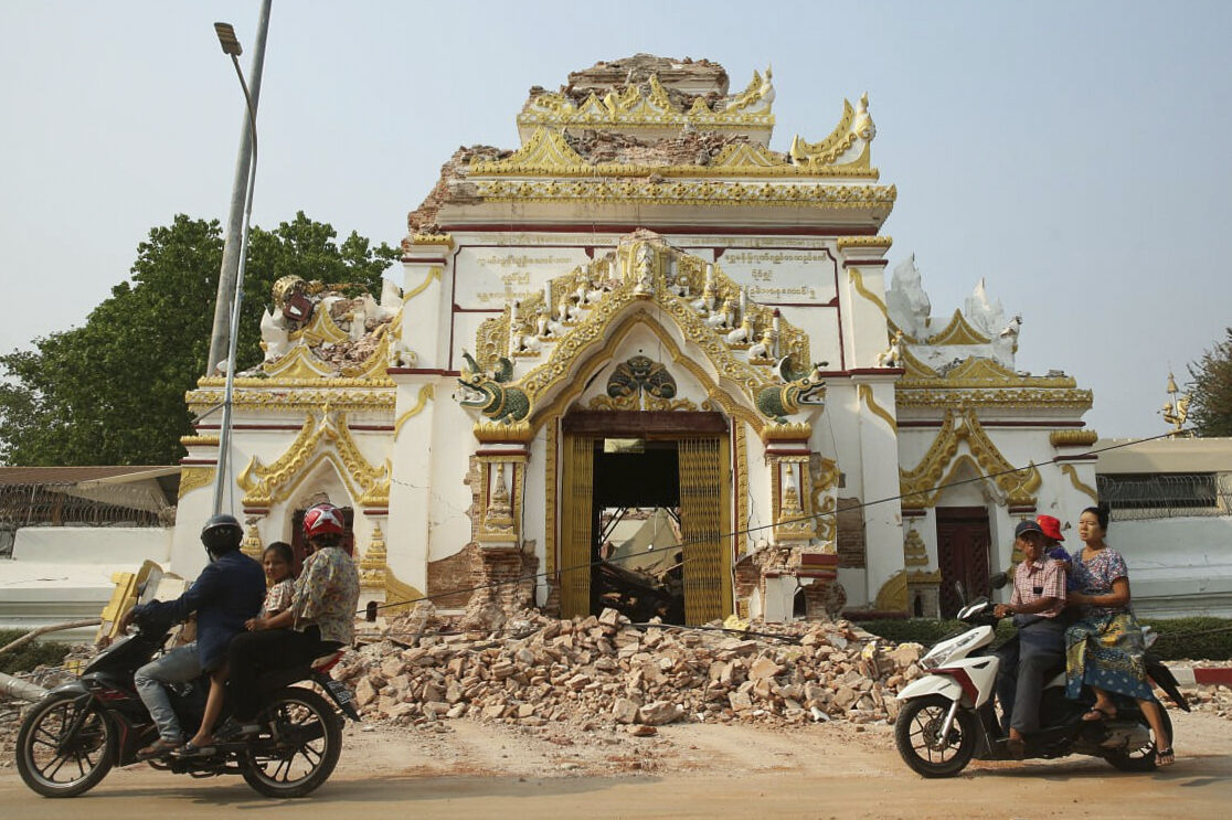 In this photo released by Xinhua News Agency, locals past by a partially damaged building in the aftermath of an earthquake in Mandalay, Myanmar on Saturday, March 29, 2025. (Myo Kyaw Soe/Xinhua via AP)