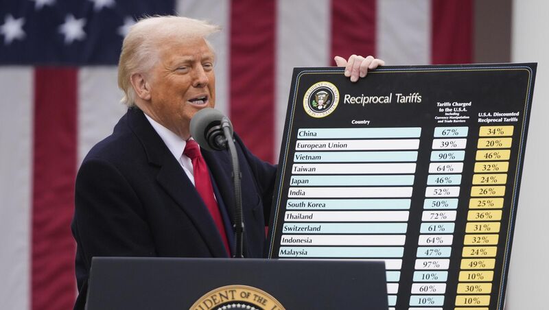 Donald Trump with the cardboard cutout of a rate card which showed which countries would be hit with which tariffs. Picture: AP/Mark Schiefelbein Donald Trump with the cardboard cutout of a rate card which showed which countries would be hit with which tariffs. Picture: AP/Mark Schiefelbein