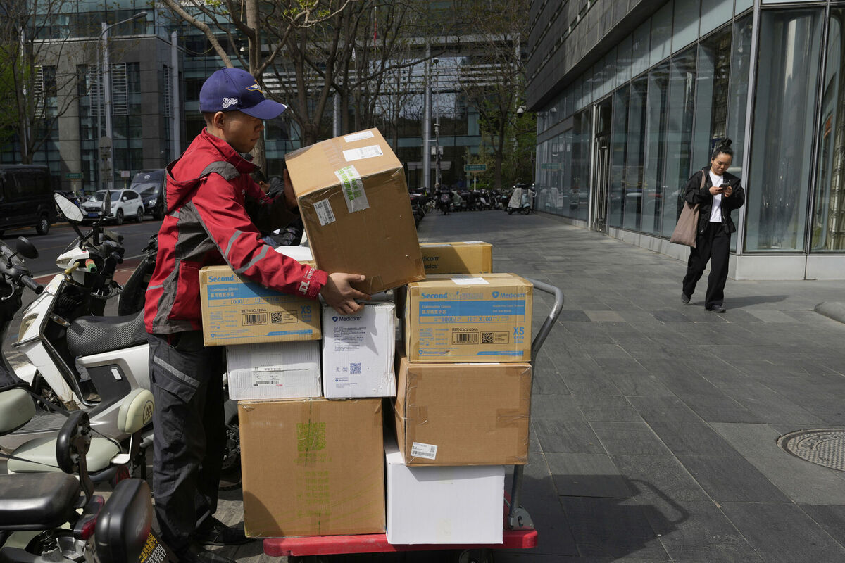A delivery man prepares his goods at the Financial Street area in Beijing, China, Tuesday, April 8, 2025. (AP Photo/Ng Han Guan)