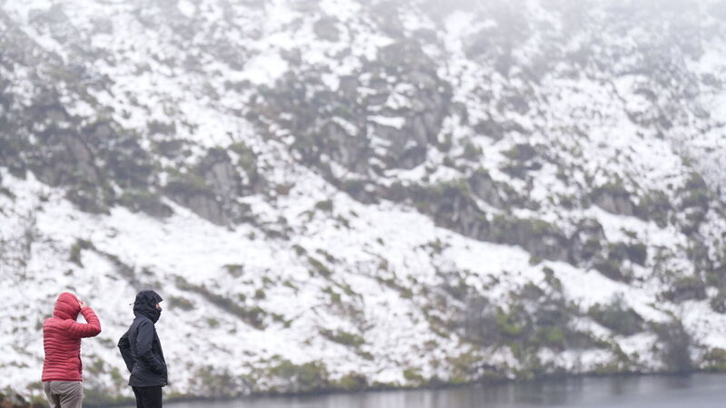 People looking at the snow at Lough Bray Upper on Powerscourt Mountain in Co Wicklow. Picture: Niall Carson/PA Wire People looking at the snow at Lough Bray Upper on Powerscourt Mountain in Co Wicklow. Picture: Niall Carson/PA Wire