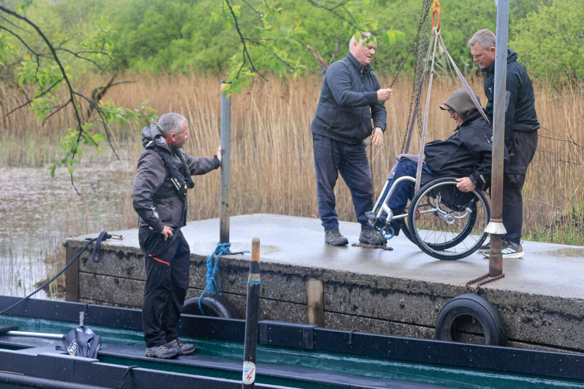 Timo O’Sullivan is hoisted onto ’An Cathal’ for its maiden voyage at Reen Pier on the Shores of Ross Castle, Lough Lein, Killarney National Park. 