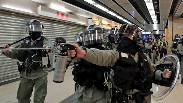 A riot police officer fires pepper spray toward people at a shopping mall in Hong Kong today. A riot police officer fires pepper spray toward people at a shopping mall in Hong Kong today.
