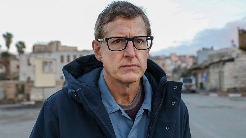 Louis is there, driving around the Palestinian territory of the West Bank with his permanently puzzled face.