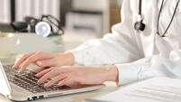 Close up of doctor woman hands typing on laptop siting on a desk at the office