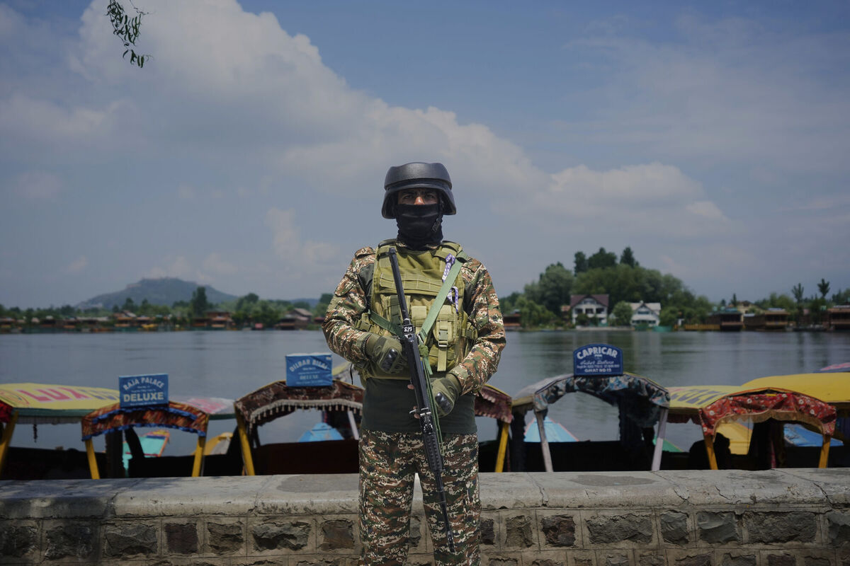 An Indian paramilitary soldier stands guard on the banks of Dal Lake after loud explosions were heard in Srinagar on Saturday. Photo: AP/Mukhtar Khan