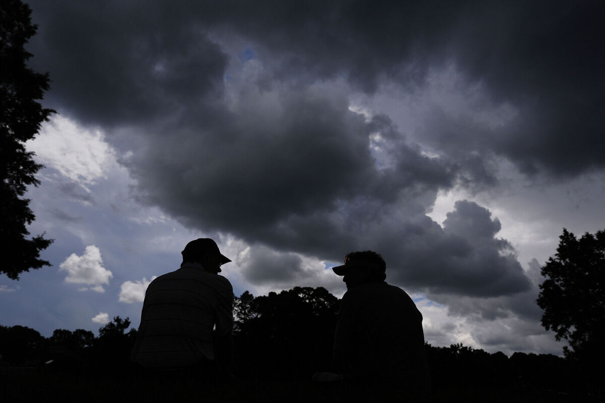 Fans wait for play to resume during a weather delay at a practice round for the PGA Championship golf tournament at the Quail Hollow Club on Tuesday. Pic: AP Photo/George Walker IV.