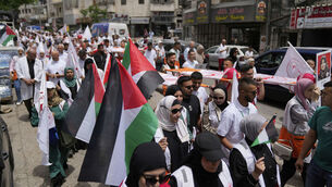 <p>Paramedics and demonstrators carry symbolic stretchers and posters with names and pictures of relief workers who lost their lives in the line of humanitarian duty, during a symbolic funeral for 48 fallen Palestinian Red Crescent Society members during the Israel Hamas war in Gaza. Picture: Nasser Nasser/AP </p>