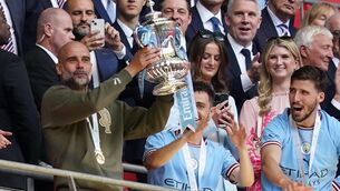 <p>Manchester City manager Pep Guardiola lifts the FA Cup.</p>