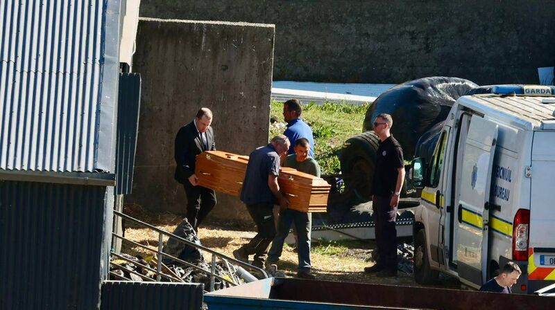 Two friends and an undertaker remove Michael Gaine's remains from his cattle shed to the hearse. Picture: Neil Michael Two friends and an undertaker remove Michael Gaine's remains from his cattle shed to the hearse. Picture: Neil Michael