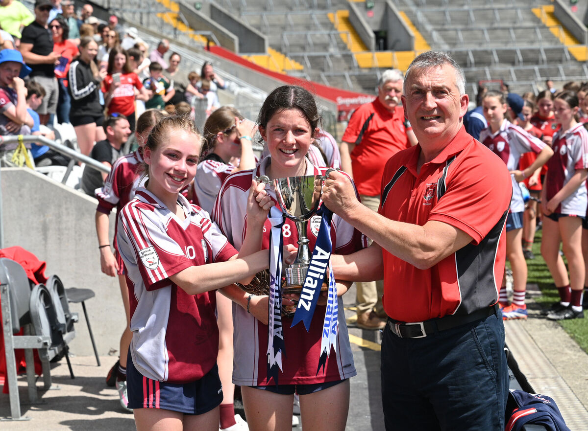  Elise Nic Eochaidh and Orlaith Ni Chearnaigh are presented with the cup by Pierce Power of Sciath na Scol. Joy for Gaelscoil Ui Riordain. after their win in the Allianz Sciath na Scol Chorcai finals at SuperValu Pairc Ui Chaoimh, Cork. CAMOGIE DC1 Riverstown v GS Ui Riordain. Picture: Larry Cummins