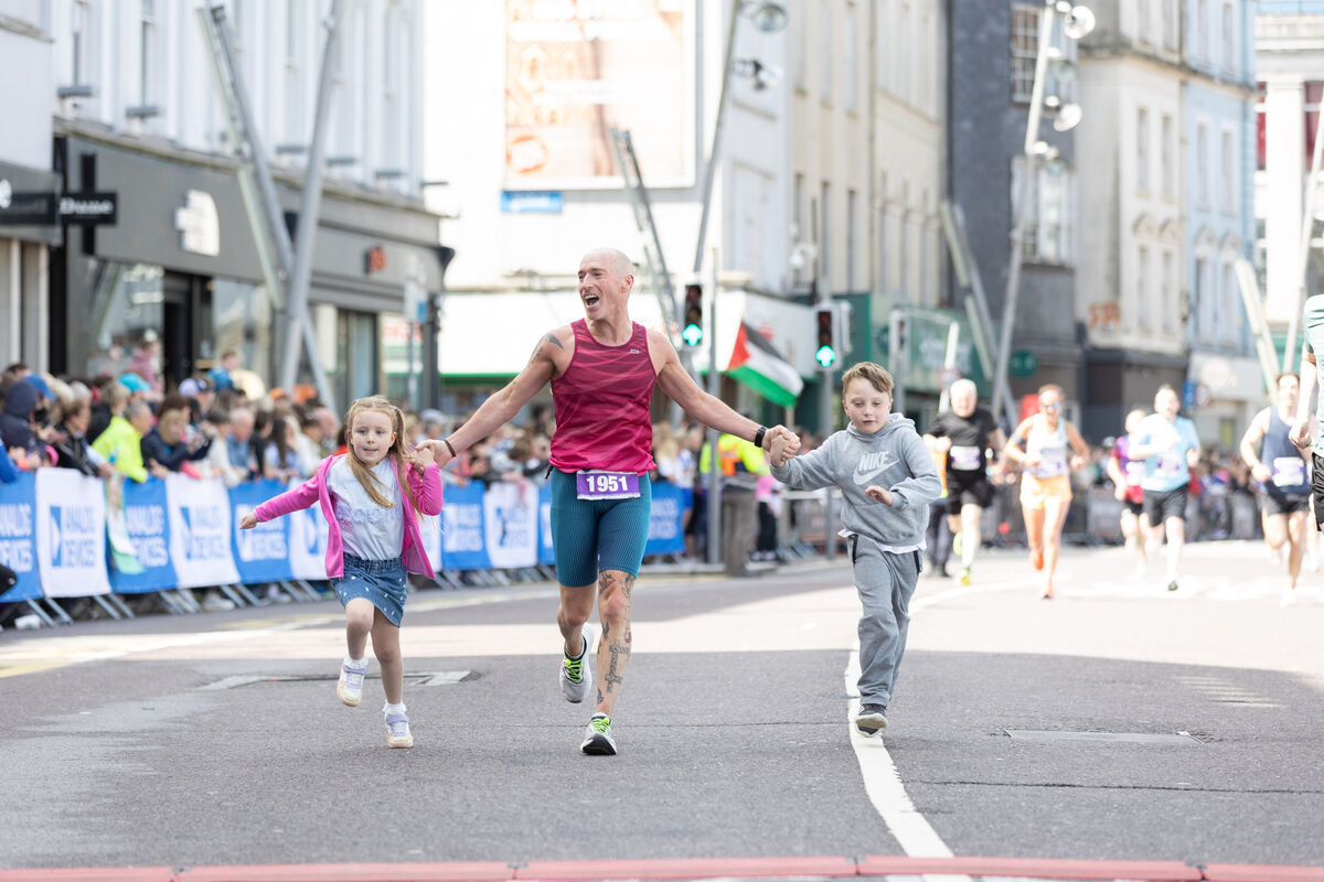 Isabelle and Bayne Butt joining their father Eddie Butt at the finish line of the Cork City Marathon 2025. Picture: Darragh Kane