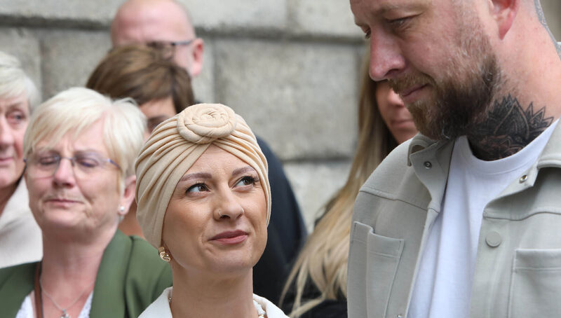 Cork native Leona Macken (centre) and her husband Alan (right) held hands as the apology from HSE’s National Screening Service chief executive Fiona Murphy was read to them. Picture: Collins Courts