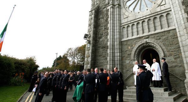 The coffin of Garda Tony Golden is carried into St Oliver Plunkett Church