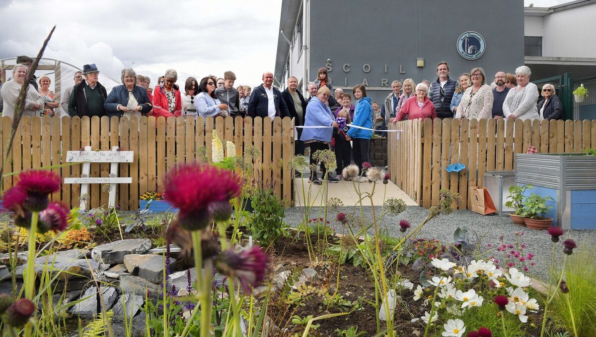  Liz Dooley, centre, cutting the ribbon at Scoil Diarmada to officially open the garden her late husband John Dooley donated to the school. Picture: Moya Nolan