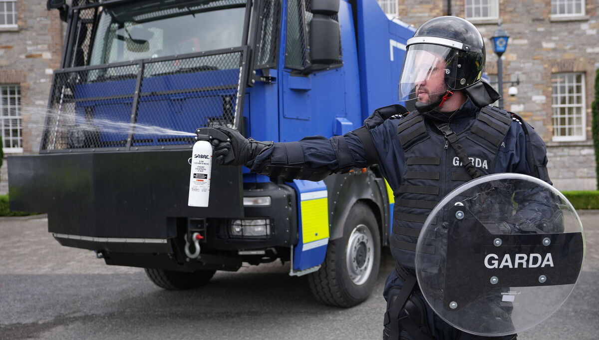 A member of the public order unit using a pepper spray next to a water cannon. Garda Commissioner Drew Harris called the new water cannons 'prudent' purchases. Picture: Niall Carson/PA