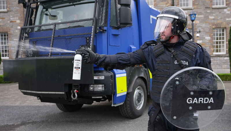 A member of the public order unit using a pepper spray next to a water cannon. Garda Commissioner Drew Harris called the new water cannons 'prudent' purchases. Picture: Niall Carson/PA A member of the public order unit using a pepper spray next to a water cannon. Garda Commissioner Drew Harris called the new water cannons 'prudent' purchases. Picture: Niall Carson/PA