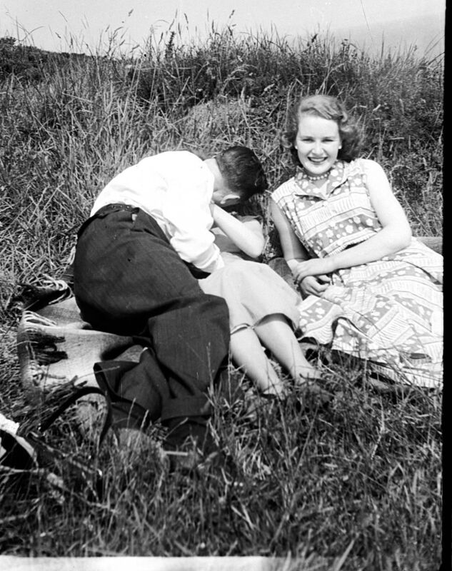 A couple kiss in the dunes. 