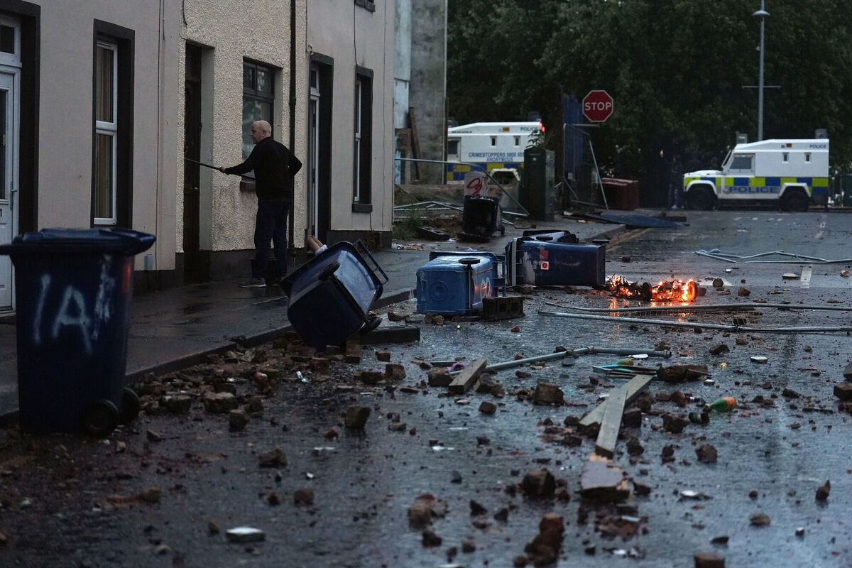 A resident clearing debris in Portadown, Co Armagh, following three nights of disorder in Ballymena. Picture: Brian Lawless/PA Wire