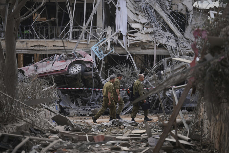Israeli security forces inspect destroyed residential buildings near Tel Aviv (Ariel Schalit/AP)