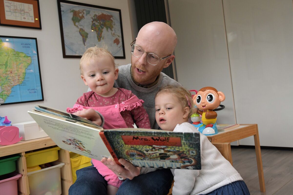  Simon Tierney reading to his daughters Giovanna 3, and Daniela 18 months. Photograph Moya Nolan