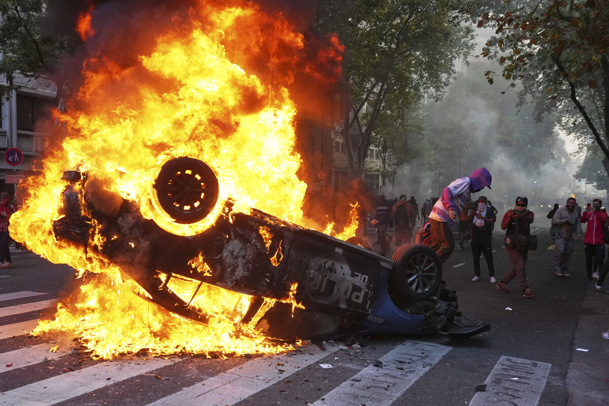 A protester burns a police car during a demonstration by soccer fans and retirees demanding higher pensions and opposing austerity measures implemented by Javier Milei's government in Buenos Aires, Argentina, in March Picture: AP/Rodrigo Abd A protester burns a police car during a demonstration by soccer fans and retirees demanding higher pensions and opposing austerity measures implemented by Javier Milei's government in Buenos Aires, Argentina, in March Picture: AP/Rodrigo Abd