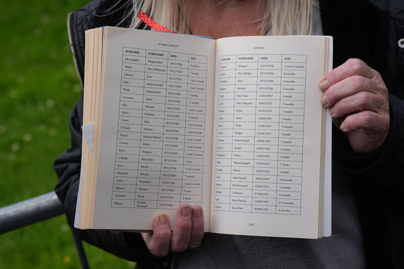 Campaigner Anna Corrigan, whose mother Bridget was resident of the Tuam Mother and Baby Home, holds up a book with a list of some of the deceased children's names Picture: PA Wire Campaigner Anna Corrigan, whose mother Bridget was resident of the Tuam Mother and Baby Home, holds up a book with a list of some of the deceased children's names Picture: PA Wire