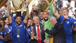 <p>US president Donald Trump, centre, with Fifa president Gianni Infantino, right, and Chelsea’s Reece James, left, as he lifts the trophy. Picture: Seth Wenig/AP</p>