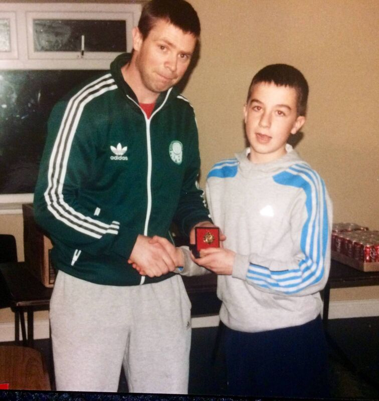 Tomás Ó Sé presenting a young Brian Ó Beaglaoich with one of his first underage medals