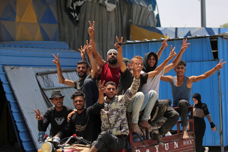 Men ride in the back of a tricycle cart along Salaheddin road in Deir el-Balah in the central Gaza Strip last week. Photo: Eyad Baba/AFP via Getty Images