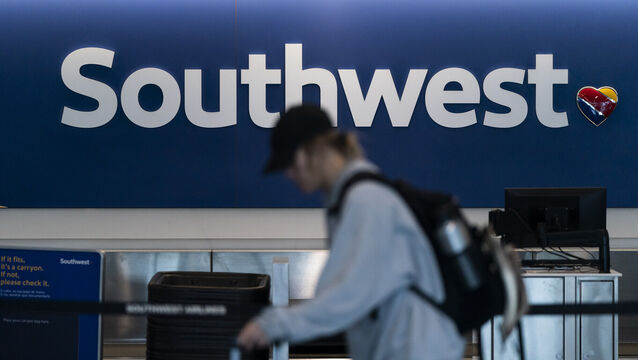 A traveller walks through the Southwest Airlines ticketing counter area at Los Angeles International Airport (Jae C Hong/AP)