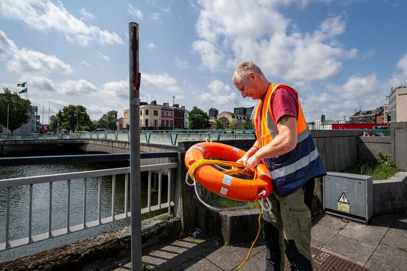 Colin Russell replaces a missing lifebuoy along Cork City’s riverside walk.