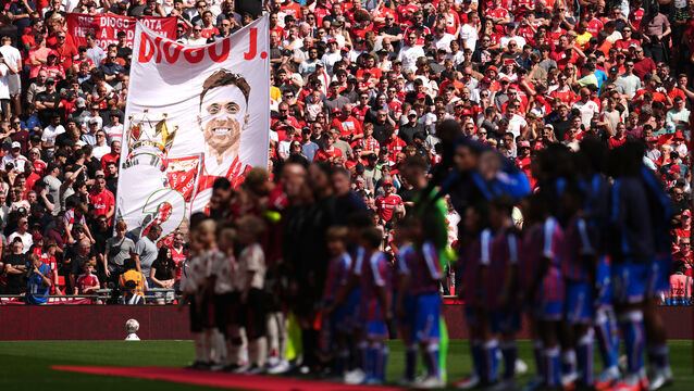 <p>Liverpool and Crystal Palace players line up as a banner in memory of Liverpool’s Diogo Jota is displayed by fans. Pic: John Walton/PA</p>