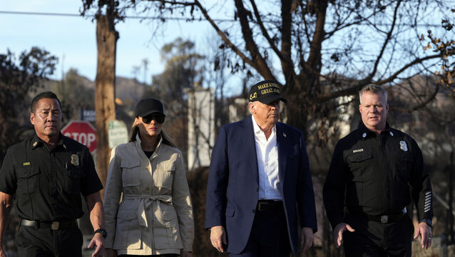 US President Donald Trump and first lady Melania Trump walk with police officers in Los Angeles (Mark Schiefelbein/AP)