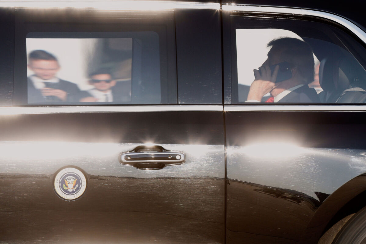 President Donald Trump, right, talks on a mobile phone in his limousine upon his arrival at Joint Base Andrews, Md., Friday, August 15, 2025, en route to a meeting with Russian President Vladimir Putin in Alaska. (AP Photo/Luis M. Alvarez)