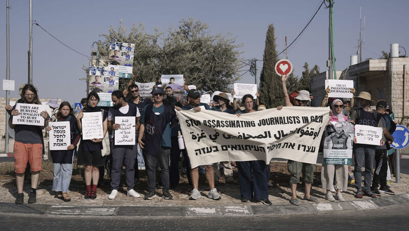Palestinian and Israeli activists take part in a protest against the killing of journalists in the Gaza Strip as they gather in the West Bank town of Beit Jala on Friday. Picture: Mahmoud Illean/AP