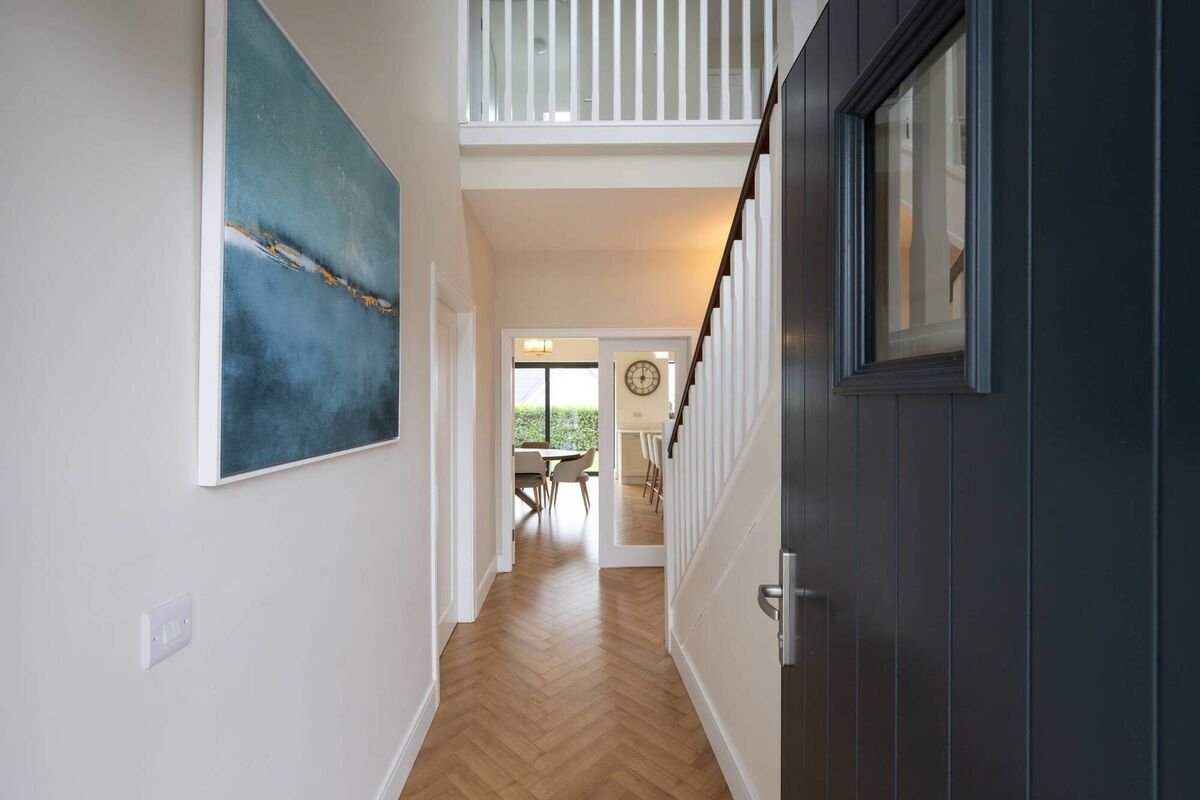 Herring bone flooring runs from the hallway into the main open-plan area