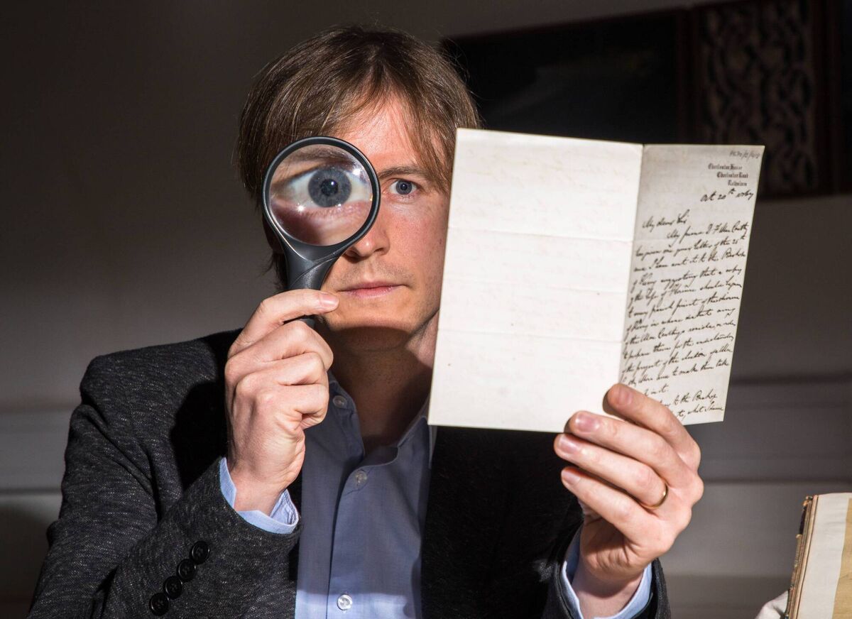 Archivist Felix Meehan examines documents that are on display at the exhibition. Picture: David Creedon