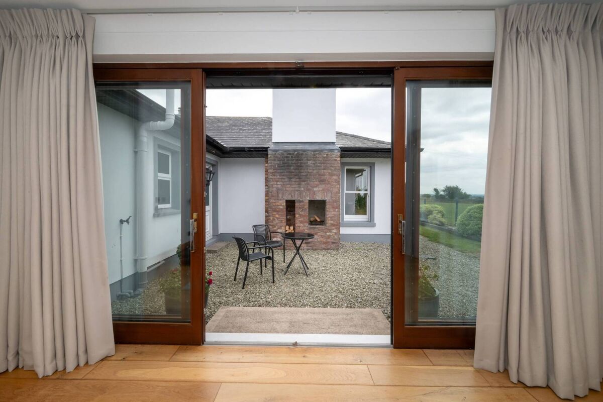 Double doors from extended bedroom lead to a courtyard