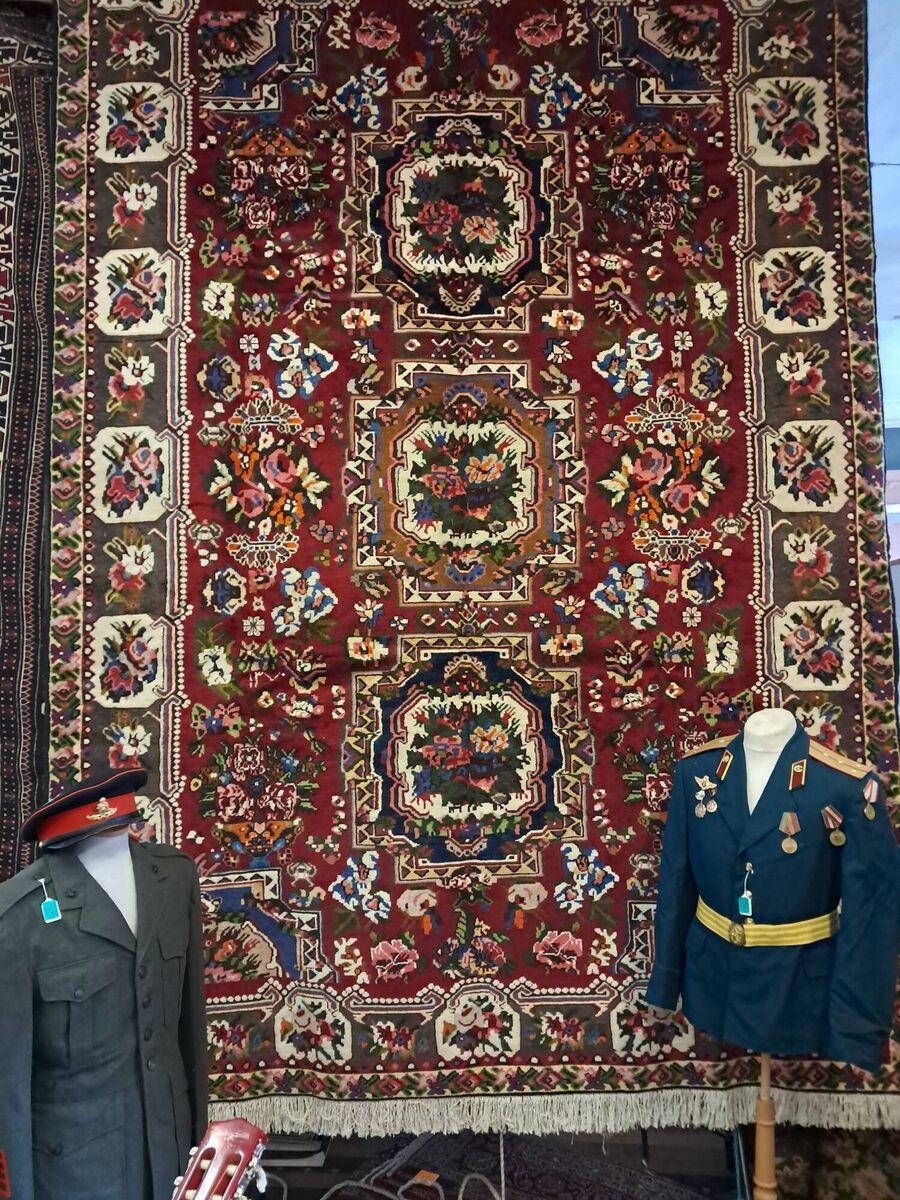 A large rug and some uniforms at Aidan Foley's sale. 