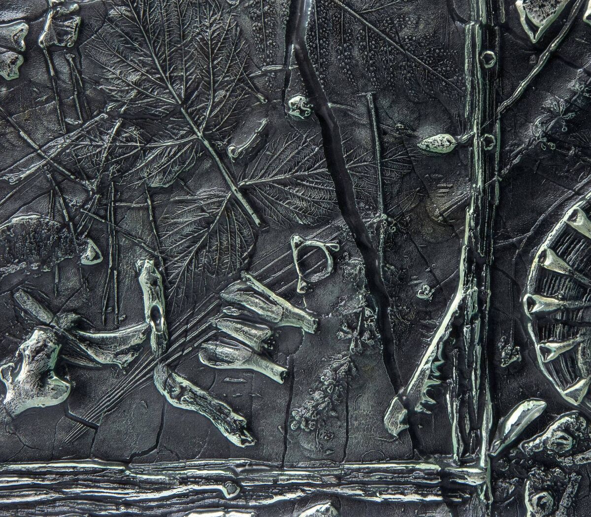  A detail of a glass relief panel made from the impressions of bone, plant remains and other materials found on site. 