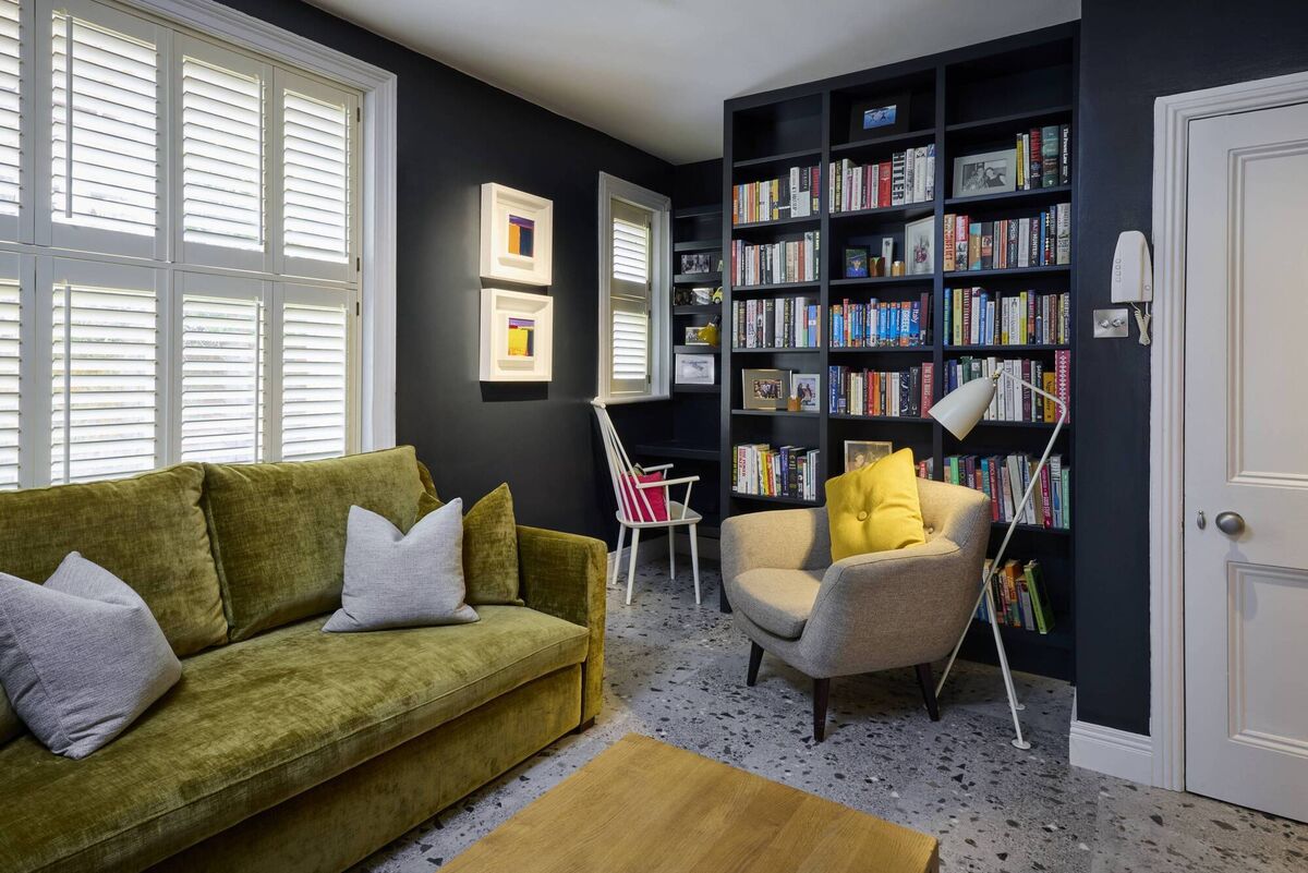 A cosy den in a grand Edwardian house in Ballsbridge, Dublin. The interior designer, Michelle Burnett of Cush Interiors, used Farrow &amp; Ball’s ‘Railings’ on the walls to enhance the cosy atmosphere. The room doubles as a library for the clients. The flooring is an Amtico terrazzo tile, which is softer underfoot than regular tiles, which adds to the sense of warmth. Picture: Ken Walsh