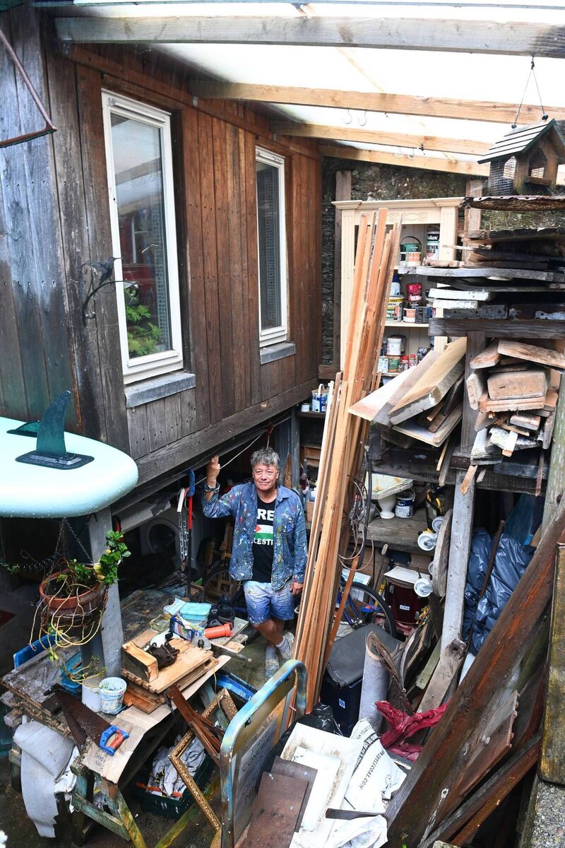Homeowner and artist John in his rear yard where he stores wood and salvage items for his studio work.
