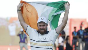 <p>HERO: Shane Lowry celebrates by hoisting the Tricolour after his putt to halve the hole and retain the Ryder Cup on the 18th green in Bethpage Black on Sunday. Picture: Harry How/Getty</p>